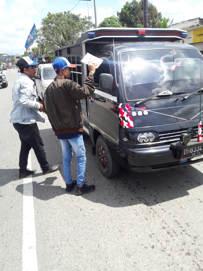 Barisan muda Jadin bagikan buku visi misi kepada masyarakat