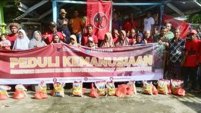 Warga Gampong Meuraksa, Kecamatan Kembang Tanjong, Pidie foto bersama dengan Relawan Jamal Idham usai menerima bantuan dari pKetua DPC PDIP Nagan Raya, Jamaluddin Idham di depan meunasah gampong setempat, Kamis (2/2/2023). (Foto: Dok. DPC PDIP Nagan Raya)